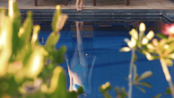 Reflection of young caucasian woman entering swimming pool — Stock Video