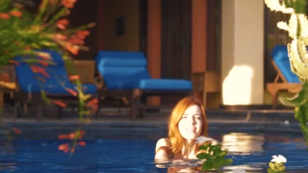 Jovem caucasiana relaxante na piscina sob sol brilhante — Vídeo de Stock