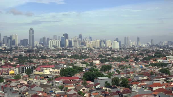 Weergave van kleine huizen en wolkenkrabbers achter hen in Jakarta, Indonesië — Stockvideo