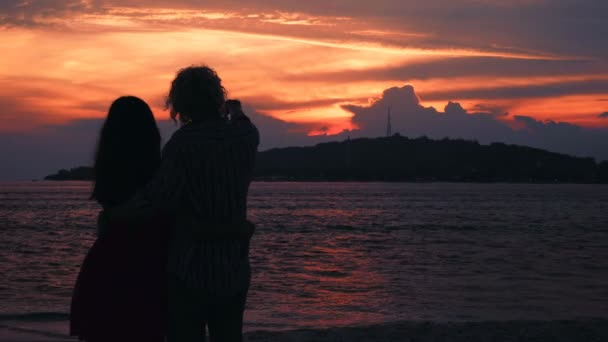 Cople przytulanie sylwetki przed ocean zachód słońca — Wideo stockowe