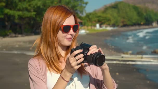 Žena pořizování fotografií na vulkanické pláže s pískem — Stock video