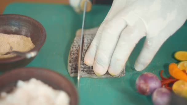 Primo piano delle mani dello chef che tagliano filetto di pesce crudo — Video Stock