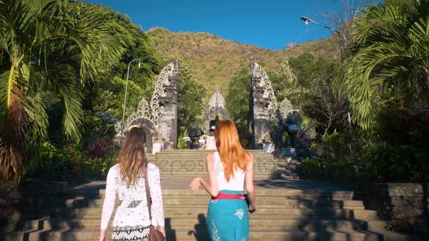 Two women walking towards Pura Melanting temple — Stock Video