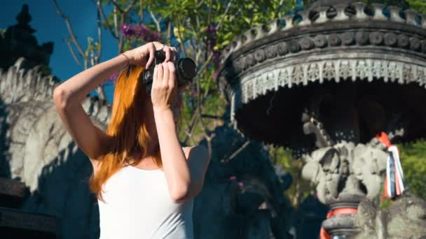 Молода жінка фотографує в балійському храмі — стокове відео