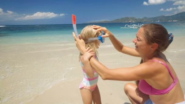 Moeder helpt dochter zetten snorkel masker — Stockvideo