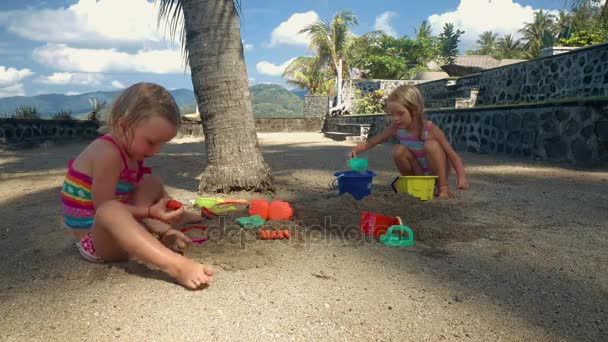 Две маленькие девочки играют с песком и водой — стоковое видео