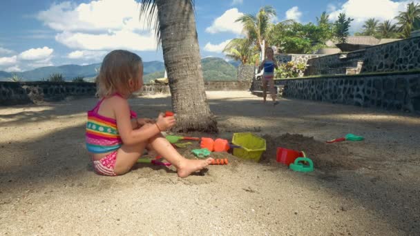 Две маленькие девочки играют с песком и водой — стоковое видео