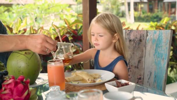 Ragazzina versando miele su frittelle sottili — Video Stock