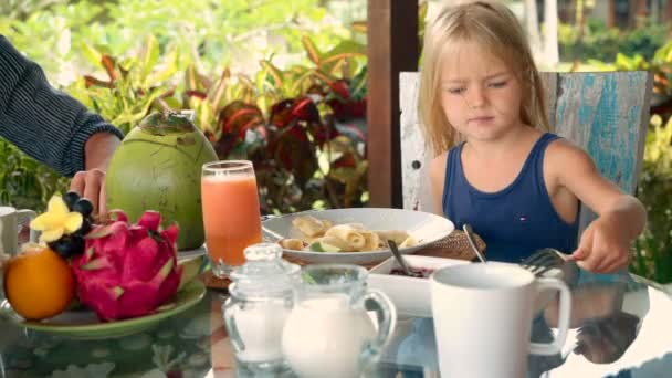 Liten flicka äter tunna pannkakor — Stockvideo