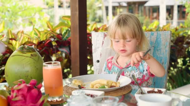Kleines Mädchen isst dünne Pfannkuchen — Stockvideo