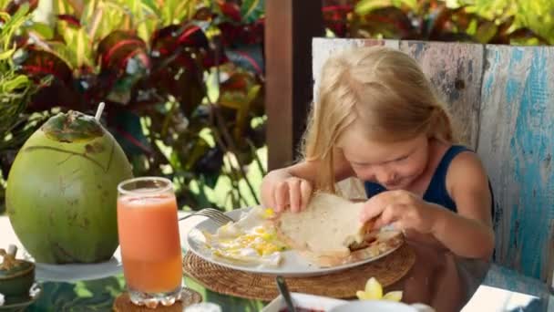 Маленька дівчинка снідає — стокове відео