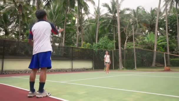 Tennis coach teaching teen girl to play — Stock Video