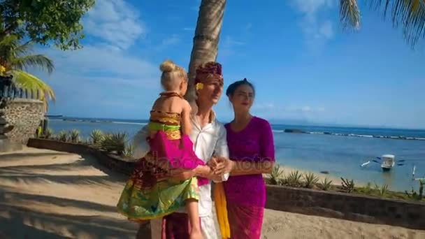 Familia en trajes balineses viendo a una adolescente aprendiendo danza balinesa — Vídeo de stock