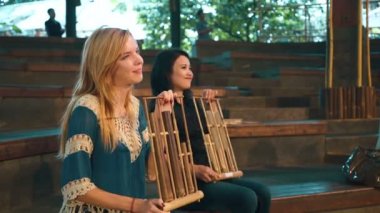 Angklung oynayan iki genç kadın