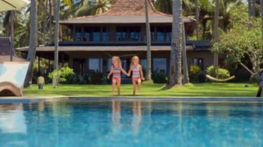 İki küçük kız havuz içine atlamak