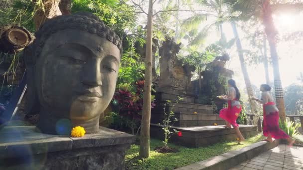 Twee vrouwen brengen van offers aan balinese tempel — Stockvideo