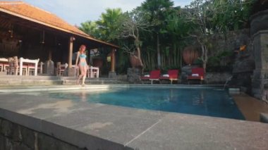 Otelin yüzme havuzu giren kadın