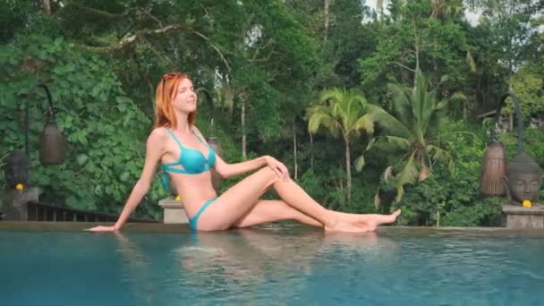 Woman sitting on edge of infinity pool — Stock Video