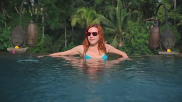 Frau schwimmt vom Rand des Infinity-Pools — Stockvideo