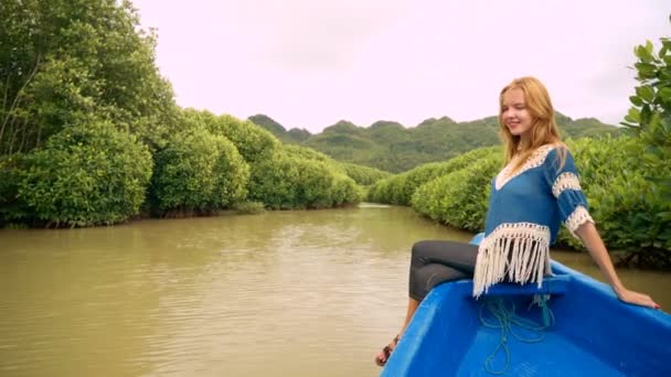 Молода жінка на носовій частині човна в мангрових горах — стокове відео