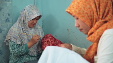İki kadın canting ile batik boyama