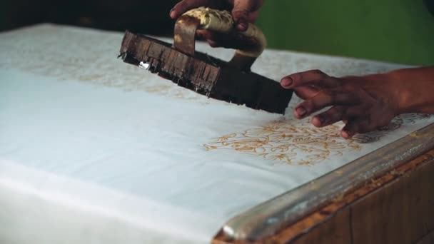 Cerrar las manos del hombre aplicando cera para hacer batik — Vídeo de stock