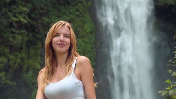 Glückliche Frau lacht vor Wasserfall — Stockvideo