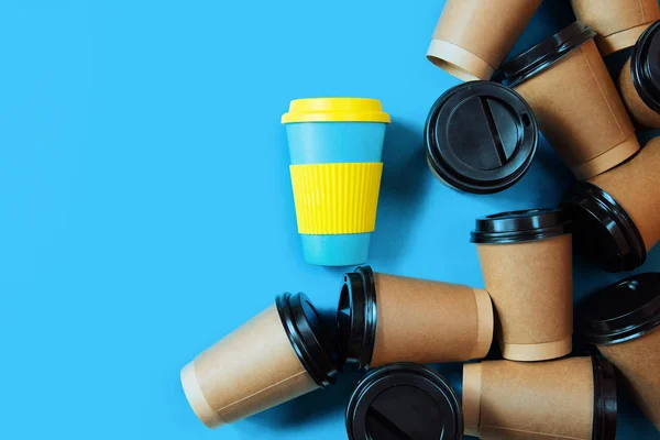 Zero-Waste-Konzept. Stilvolle wiederverwendbare Öko-Kaffeetasse und mehrere Einweg-Pappbecher. Verbot von Einwegplastik. — Stockfoto