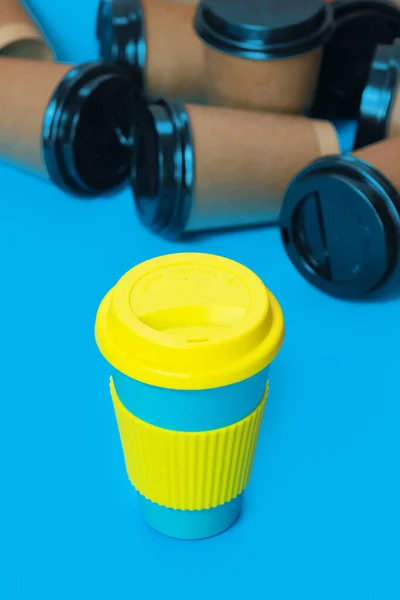에코 커피 컵 과 여러 개의 단일 사용 판지 컵을 사용하고 있다 . defocused photo. — 스톡 사진