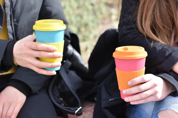 Две девушки сидят на улице, держа чашку кофе. Устойчивый образ жизни — стоковое фото