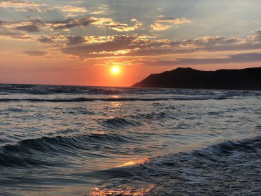 Adriyatik Denizi üzerinde çarpıcı bir günbatımı. Gökyüzünde turuncu renkli derin alevler. Mükemmel soyut bir arka plan. Fotoğraf 8 Temmuz 2018 'de Arnavutluk' un Golem kentinde çekildi.