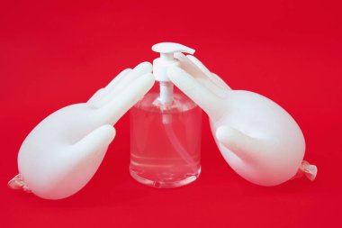 Kırmızı arka planda el dezenfektanı için antibakteriyel jeli kapat.