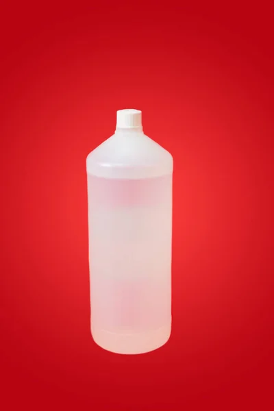 Κοντινό λευκό μπουκάλι αλκοόλ σε κόκκινο φόντο. — Φωτογραφία Αρχείου