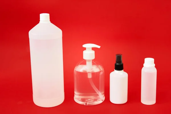 Coronavirus protection hand hygiene. Many hand sanitizer bottles on red background. Alcohol gel antibacterial soap sanitizer, hands disinfection. Hygiene protection Coronavirus Covid 19 concept.