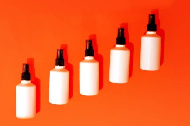 Turuncu arka planda el dezenfektanı antibakteriyeli sprey.