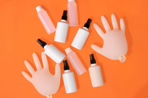 Désinfectant pour les mains à base d'alcool, gants sur fond orange . — Photo