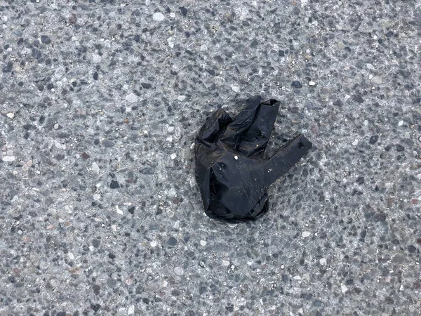 Close-up zwart medisch handschoen verlaten op de weg. — Stockfoto