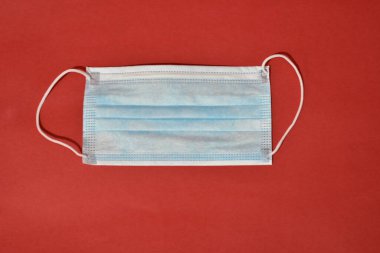 Kırmızı arka planda tıbbi koruyucu maske. Sağlık hizmetleri kavramı