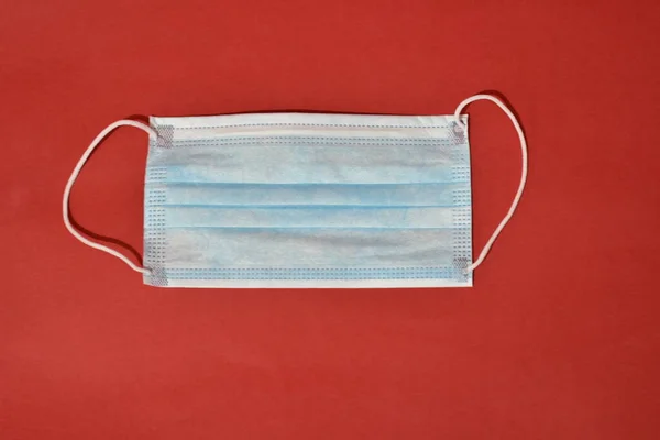 Medical protective mask on red background. Healthcare concept
