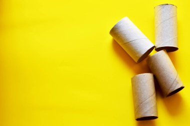 Coronavirus salgını sırasındaki kağıt tüpleri, sarı arkaplan.