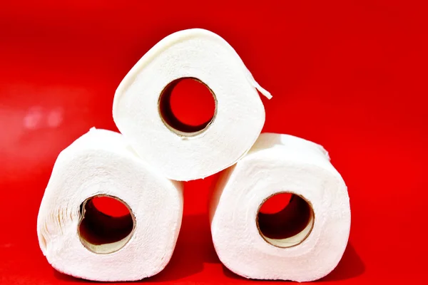 Rulla toalettpapper på röd bakgrund — Stockfoto