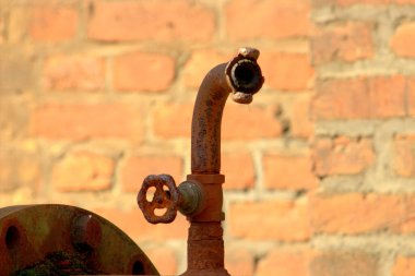 Eski bir fabrikada kapama vanası olan paslanmış demir boru.