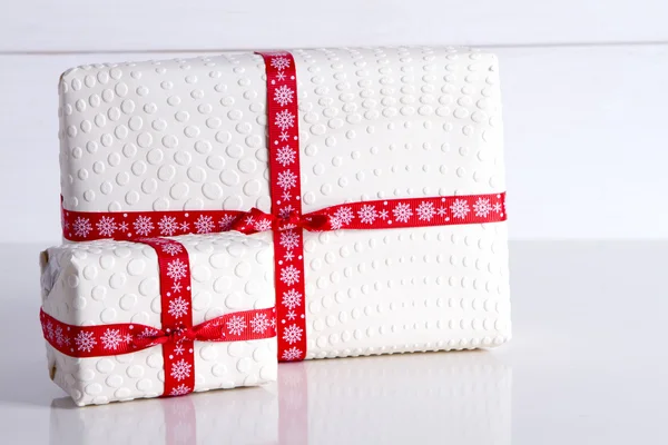 Dos cajas de regalo blancas con lunares una cinta roja . — Foto de Stock