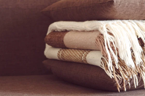 Плейды и подушки на диване в куче коричневых оттенков — стоковое фото