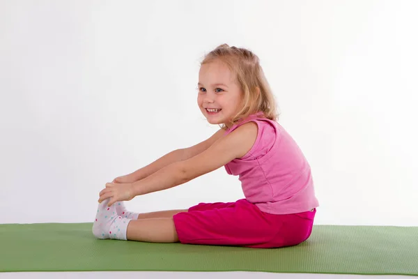 Kind macht Bewegungsübungen auf dem Teppich — Stockfoto