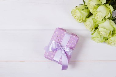 Vintage ışık masanın üzerine çiçek ve hediye kutusu kurdele ile gül.