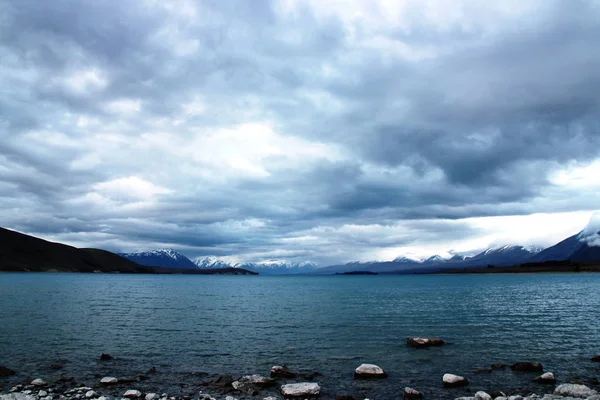 Tekapo Gölü, bulutlu bir günde akşam üstü. Yeni Zelanda