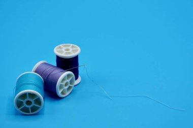 Mavi arkaplanda dikiş iğnesi olan mavi, mor ve çivit renkli bir grup.