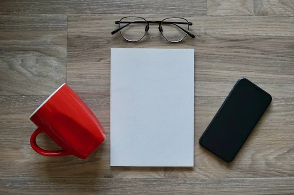 Επίπεδη lay κόκκινο φλιτζάνι καφέ, βιβλίο, γυαλιά ηλίου και έξυπνο τηλέφωνο — Φωτογραφία Αρχείου