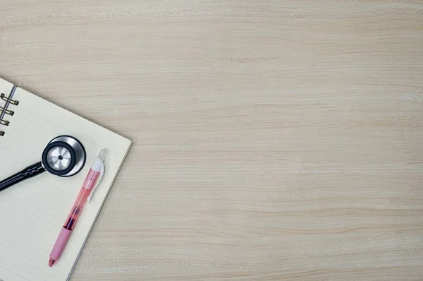 Płaski układ książki, stetoskop i długopis na drewnianym stole — Zdjęcie stockowe